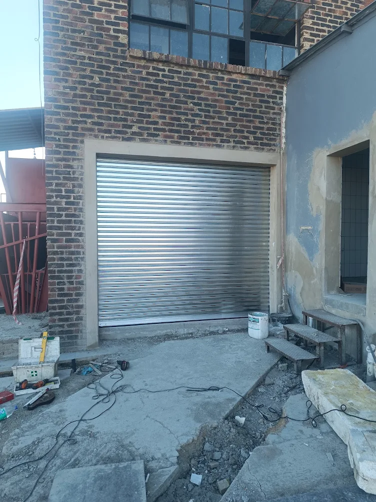 Small silver roller shutter door installed on building opening